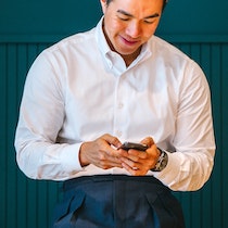 Image of person sitting down looking at their phone